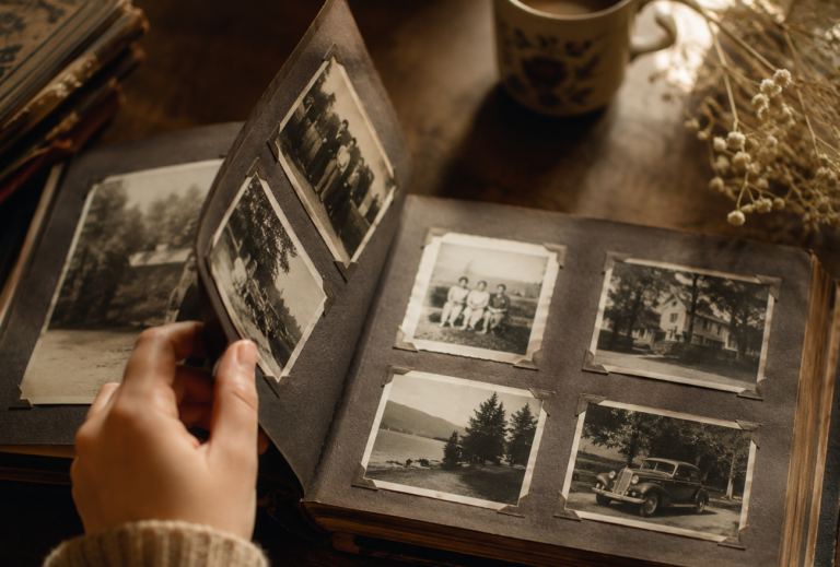 A hand turning the pages of an old photograph album filled with vintage memories.
